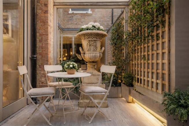 Private patio garden with stone urn and trellis