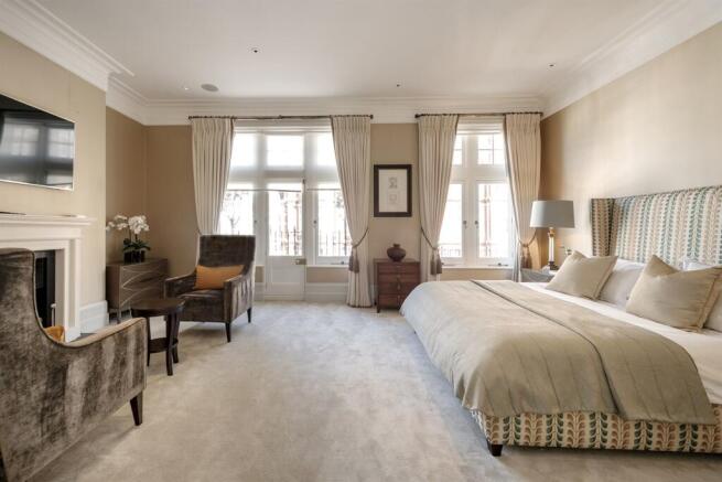 Principal bedroom suite with fireplace and balcony windows